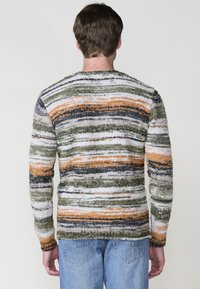 Multikleurige gebreide trui met banden van oranje, groen, marineblauw en witte strepen. Zachte textuur met een relaxte pasvorm en lange mouwen.