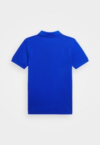 Litte sinimust polosärk lühikeste varrukatega, mille tagakülg on ülespoole, laiutatuna valge taustal.