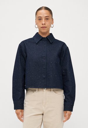 Cropped dark blue denim jacket with a collar, featuring scattered light embellishments. Long sleeves with buttoned cuffs.