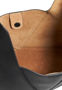 Black leather handbag with a soft suede interior. Features a snap closure, smooth edges, and a zippered pocket inside.