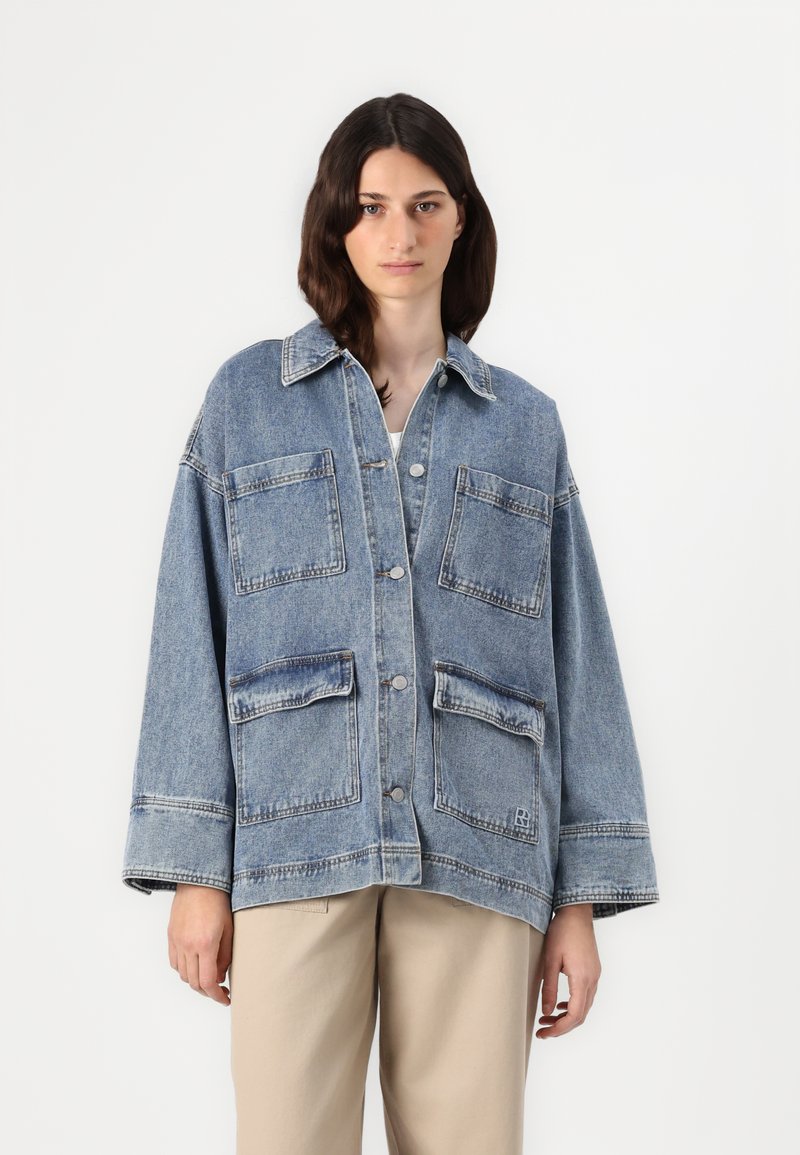 Jeans jakna svijetlo plave boje s opuštenim krojem, velikim prednjim džepovima, strukturiranim ovratnikom i kopčanjem na dugmad. Sadrži kontrastne šavove.