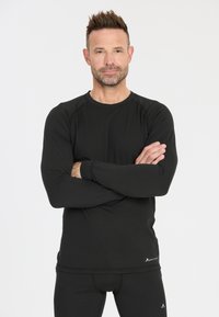 Black long-sleeve athletic shirt with a round neckline, fitted shape, and smooth texture, paired with black athletic bottoms.