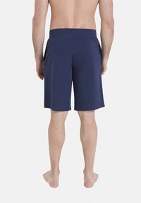 Shorts bleu marine en tissu doux, présentant un design simple avec une coupe droite et une taille élastique, visibles de dos.