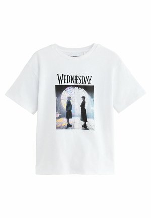 Hvid T-shirt med en grafik, der viser to figurer, der står overfor hinanden inde i et rum med et stort rundt glasmosaikvindue og spindelvæv.