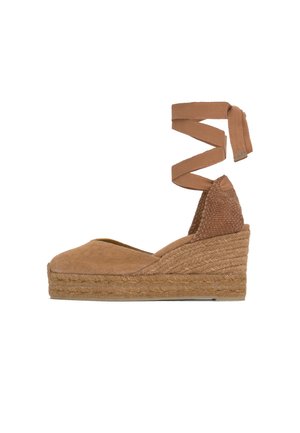 Zapato espadrille con cuña marrón, punta cerrada, suela de plataforma de cuerda tejida y largas cintas para atar alrededor del tobillo.