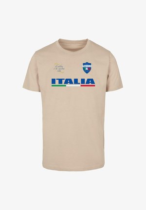 Beige puuvillane t-särk, millel on boldsinine tekst "ITALIA" ja roheline ning punane triip all. Särk sisaldab sinist kilbi logo ja trükitud teksti üleval.