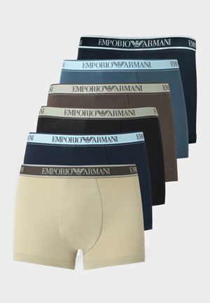 Šesť párov pánskych boxeriek Emporio Armani v béžovej, námorníckej modrej, čiernej, hnedej, modrej a znovu v čiernej farbe, naskladaných do stupňovitého tvaru.