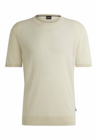 Helles beige T-Shirt mit kurzen Ärmeln aus weichem Stoff. Hat einen gerippten Ausschnitt und Rippenbündchen, mit einem kleinen Logotag am Saum.