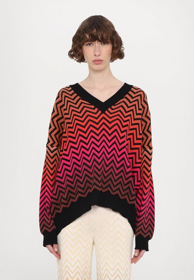 Pull en maille à col V avec un motif en chevrons dans des couleurs dégradées allant du noir au rouge et au rose, doté de manches longues et d'une coupe décontractée.