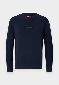 Granatowy sweter dzianinowy z okrągłym dekoltem. Posiada logo "TOMMY JEANS" w białym kolorze na klatce piersiowej. Ściągacze przy mankietach i u dołu.