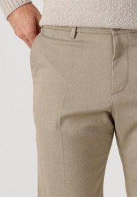 Beige dress pants with a smooth texture, featuring side pockets and a straight cut. A subtle pattern is visible in the fabric.
