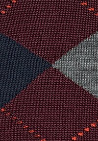 Tejido de punto con un patrón de diamantes en borgoña, azul marino y gris, con costuras naranjas que aportan textura y contraste.