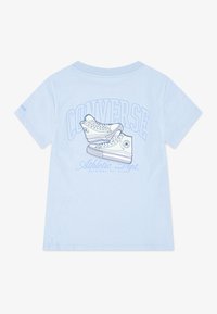 Světle modré bavlněné tričko s grafikou dvou tenisek Converse a textem "CONVERSE Athletic Dept." ve světle modré. Krátké rukávy, standardní střih.