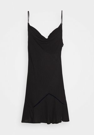 Vestido negro sin mangas con escote drapeado, dobladillo acampanado y un discreto detalle de costura diagonal en la base. Tela suave y ligera.