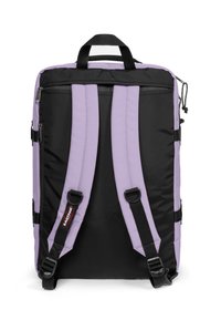 Svart och lavendel vadderad ryggsäck med justerbara axelremmar, ett handtag på toppen och flera dragkedjefack på sidorna.