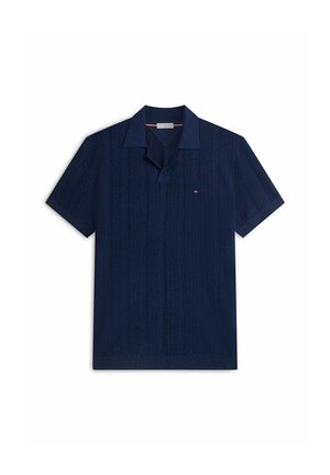 Polo blu navy a maniche corte con righe verticali testurizzate e piccolo logo rosso, bianco e blu sul petto sinistro.