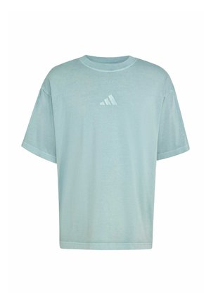 Lyseblå oversized t-skjorte laget av mykt stoff. Har rund hals og et lite hvitt Adidas-logo på brystet. Korte ermer.
