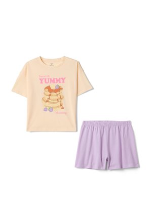 Camiseta beige de manga corta con texto rosa "Sweet & YUMMY Morning" y gráfico de panqueque, combinada con pantalones cortos lilas con cintura elástica.