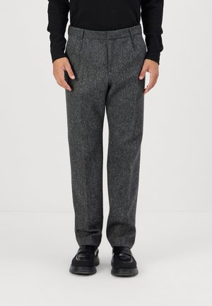 Grey wool trousers with a textured finish, featuring a flat front, side pockets, and a slightly tapered leg design. Worn with black shoes.
