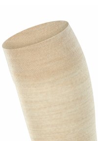 Beige Kompressionsstrumpf mit glatter Textur, zylindrischer Form und einem leicht breiteren oberen Bündchen. Das Material scheint dehnbar und atmungsaktiv zu sein.