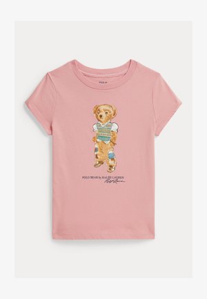 Pink kortærmet T-shirt med grafik af en stående bjørn iført vest, lappede bukser og støvler med teksten Polo Bear af Ralph Lauren.