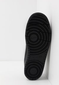 Mustade spordijalatsite talla, millel on kontsentrilised ringikujulised mustrid, "Nike" bränding ning tekst "All Day Play"; valmistatud vastupidavast kummimaterjalist.