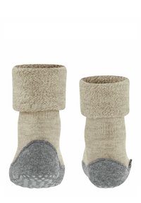 Calze lavorate a maglia beige con risvolto, suola in feltro grigia e punti di gomma per garantire grip. Texture morbida, lunghezza fino al polpaccio, progettate per il massimo comfort.