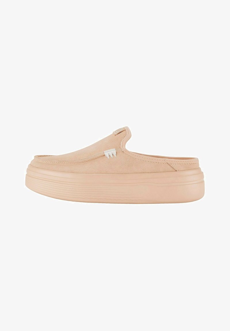 Chaussures slip-on en daim pêche clair avec un bout arrondi, semelle plateforme avec des rainures horizontales et un discret logo sur le côté.
