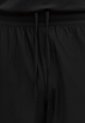 Sorte atletikshorts med elastisk taljebånd med tekstureret bånd, bundet med flade snore for en sikker pasform.