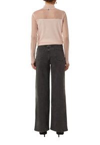 Helles rosa Langarmshirt mit transparentem Rückendetail, kombiniert mit hoch taillierten, weit geschnittenen dunkelgrauen Jeans. Sanfte Textur und lässiges Design.