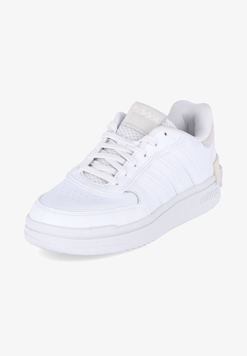 Des chaussures de sport blanches avec une tige en cuir synthétique lisse, une semelle en caoutchouc plate et trois rayures sur le côté. Elles sont dotées d'un col rembourré et de lacets.