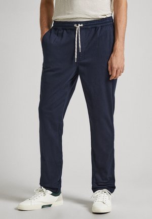 Pantalones jogger ajustados de color azul marino, hechos de tela suave, con cintura elástica y cordón, y bolsillos laterales.