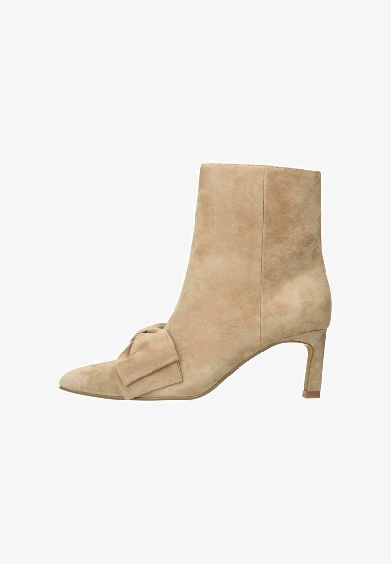 Bottine en suède beige à bout pointu, avec un nœud décoratif sur le côté et un talon fin. Texture lisse avec un éclat subtil.