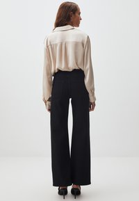 Jimmy Key WIDE LEG SHINY STONES - Jeans a zampa - black