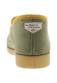 Chausson en suede vert avec un col en tissu jaune, présentant une étiquette au dos indiquant "La Maison de L'Espadrille - 1960".