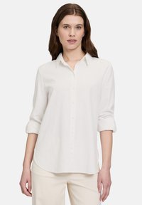 Weißes Button-up-Hemd aus leichtem Stoff, mit Kragen, hochgerollten langen Ärmeln und abgerundetem Saum für eine lässige Passform.