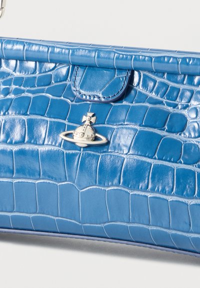 Μπλε πορτοφόλι από δέρμα με ανάγλυφο κροκόδειλο, με αργυρό έμβλημα σφαίρας και δαχτυλιδιού στο εμπρόσθιο κλείσιμο.