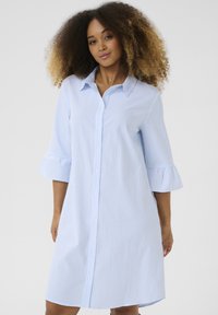 Abito camicia con bottoni in blu chiaro e righe bianche. Caratterizzato da colletto, maniche a tre quarti con volant e vestibilità comoda.