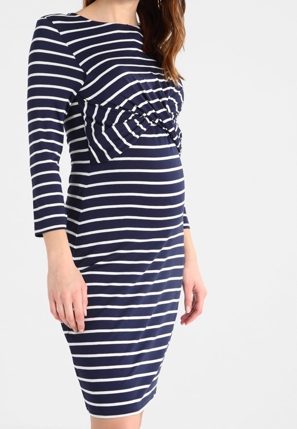 Robe de maternité rayée bleu marine et blanc, longueur genou, manches longues avec un détail torsadé froncé au niveau de la poitrine.