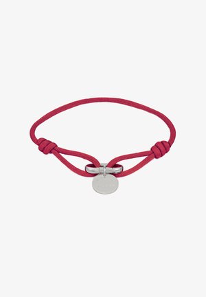 Rotes Textilarmband mit silberner Metallverschlus und rundem Anhänger, der mit "CP STUDIOS" graviert ist. Glatte Textur mit geknotetem Design.