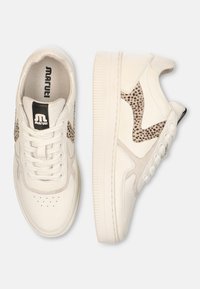 White sneaker with textured leather, featuring a spotted beige accent on the side, round toe, and rubber sole with perforations.