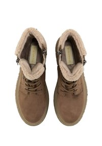 Bottines en suède marron avec une douce doublure en fausse fourrure beige, lacets à l'avant et détail de fermeture éclair sur le côté. Semelle en caoutchouc plate.