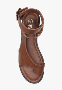 Brun læder sandal med ankelrem, �åben tå-design, buede kanter og syede detaljer på sålen. Flad sort ydersål.