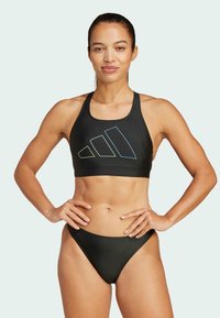 Bikini sportivo nero con top aderente decorato da un logo multicolore Adidas, progettato per comfort e attività sportive. Texture liscia.
