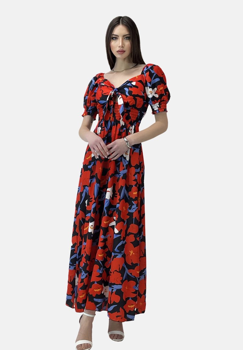 Maxi abito rosso con motivi floreali blu e bianchi; presenta un corpetto arricciato, maniche a sbuffo e un dettaglio con fiocco sul collo.