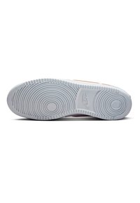 Suela de zapatilla de goma blanca con patrones de tracción circulares y un logo prominente. Secciones texturizadas que mejoran el agarre y la tracción.