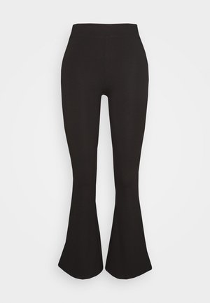 Pantalon noir ajusté à taille haute et jambes évasées présenté sur un fond clair uni.