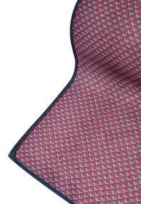 Czerwono-niebieska wykładzina w geometryczny trójkątny wzór, z ciemnoniebieskim brzegiem i teksturowaną powierzchnią tkaniny.