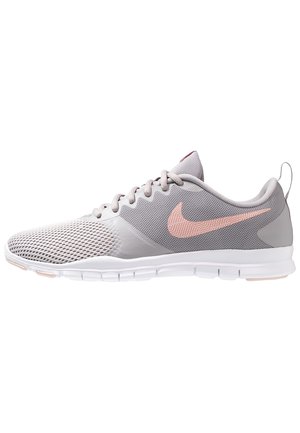 Hellgrauer Sportschuh mit atmungsaktivem Mesh, weißer Sohle, pinkem Nike-Swoosh und Schnürverschluss, von der Seite auf weißem Hintergrund.