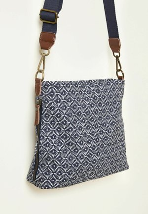 Laivastonsininen kangaspäällinen olkalaukku, jossa valkoinen kukkakuosi, ruskeat nahkaiset yksityiskohdat ja säädettävä hihna. Varustettu vetoketjullisella suljennalla ja tekstiilipintaisella rakenteella.